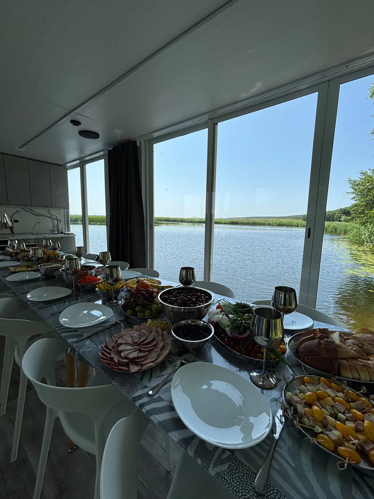 Праздничная подача с фруктами и закусками на хаусботе у панорамных окон