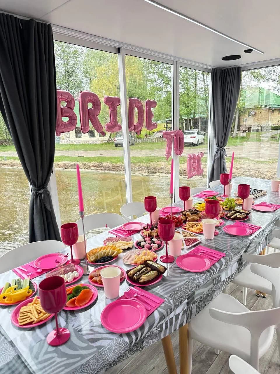 Праздничный стол с розовой сервировкой внутри хаусбота для девичника или дня рождения